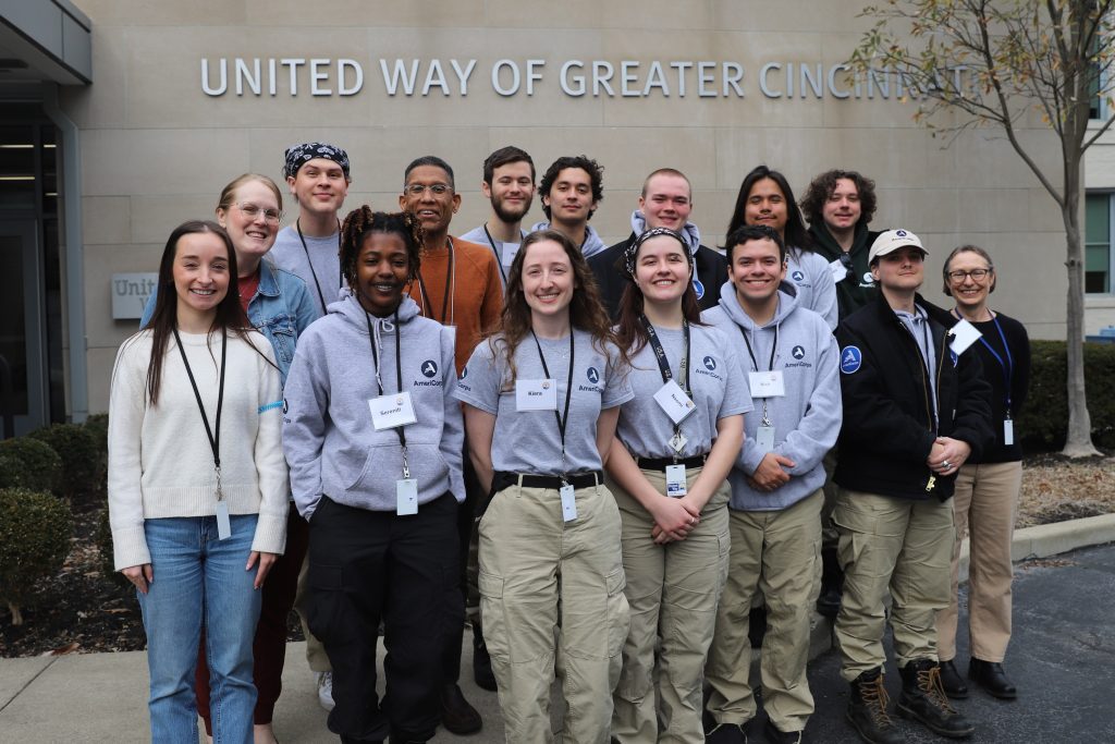 A group 15 of people pose in front of the United Way of Greater Cincinnati building.